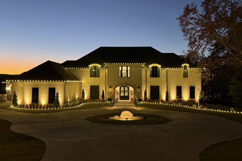Elegant mansion with warm white holiday lights at dusk